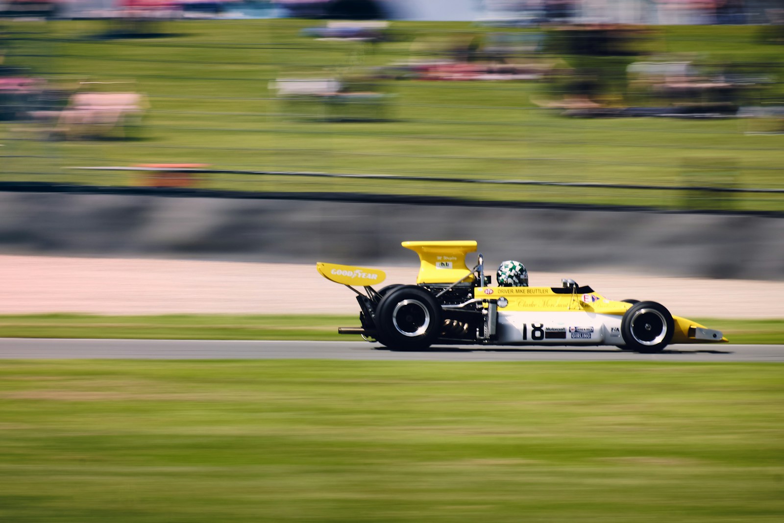 a yellow race car driving down a race track