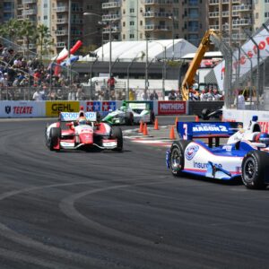 a group of racing cars driving down a race track