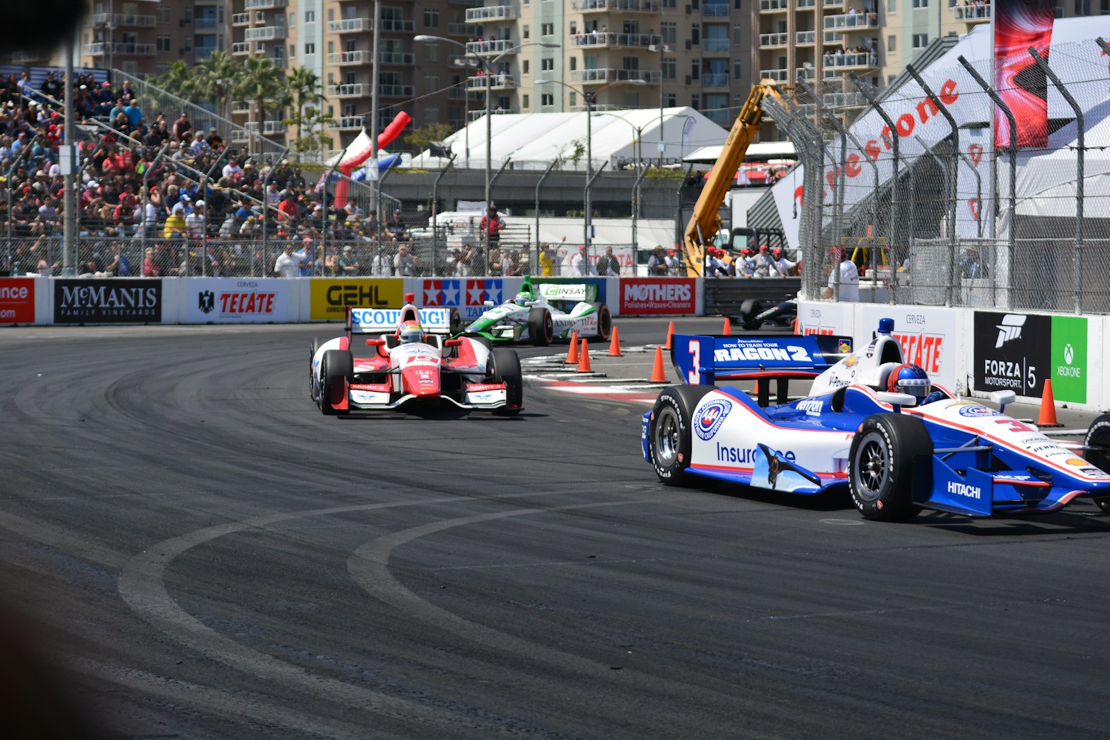 a group of racing cars driving down a race track